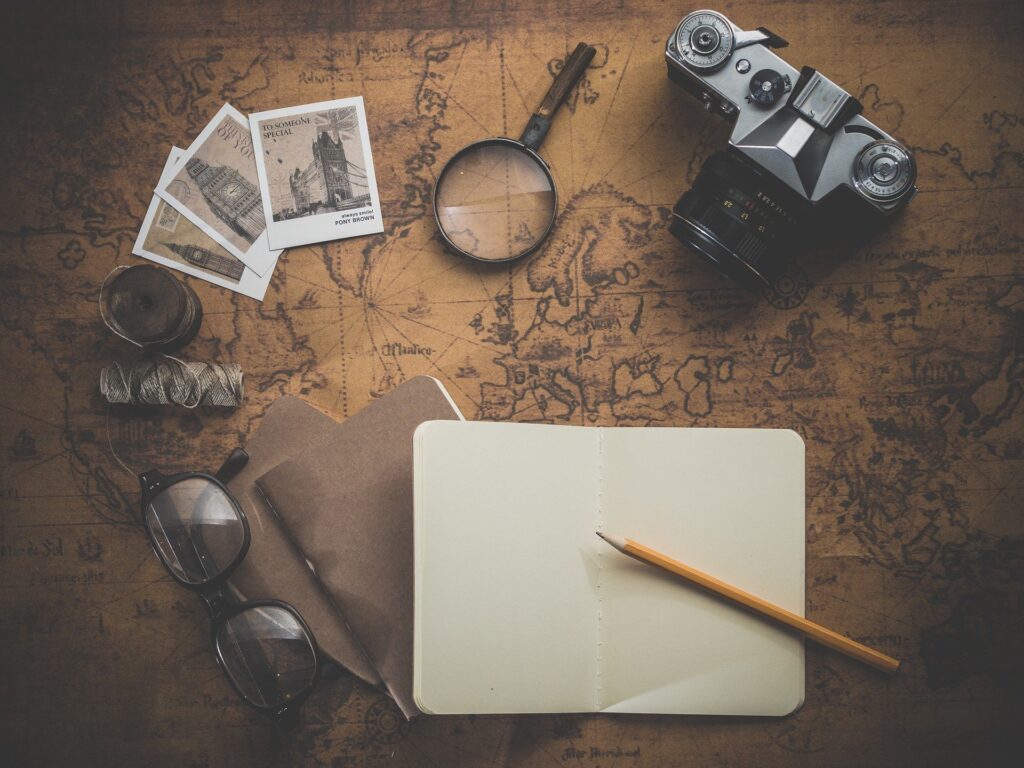 map. notebook. camera. photos. sunglasses. holiday planning