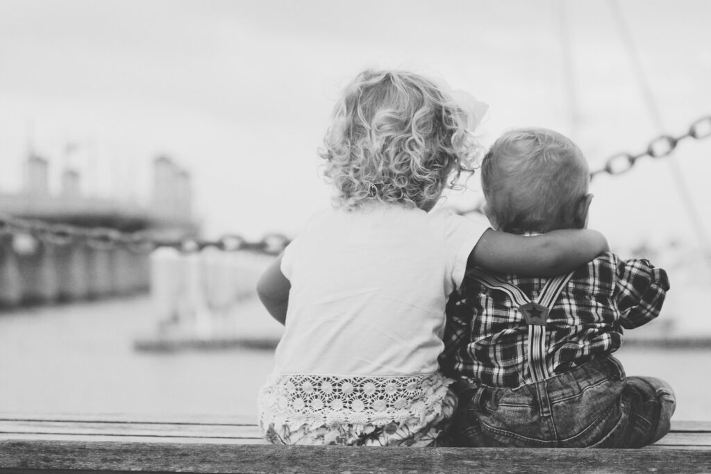 black and white image of two children hugging